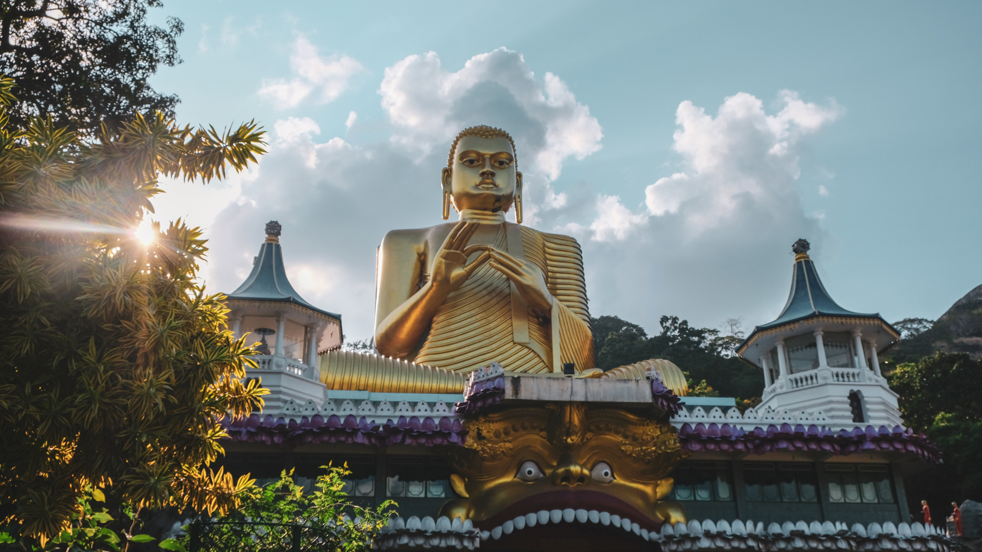 A large golden Buddha statue above a temple