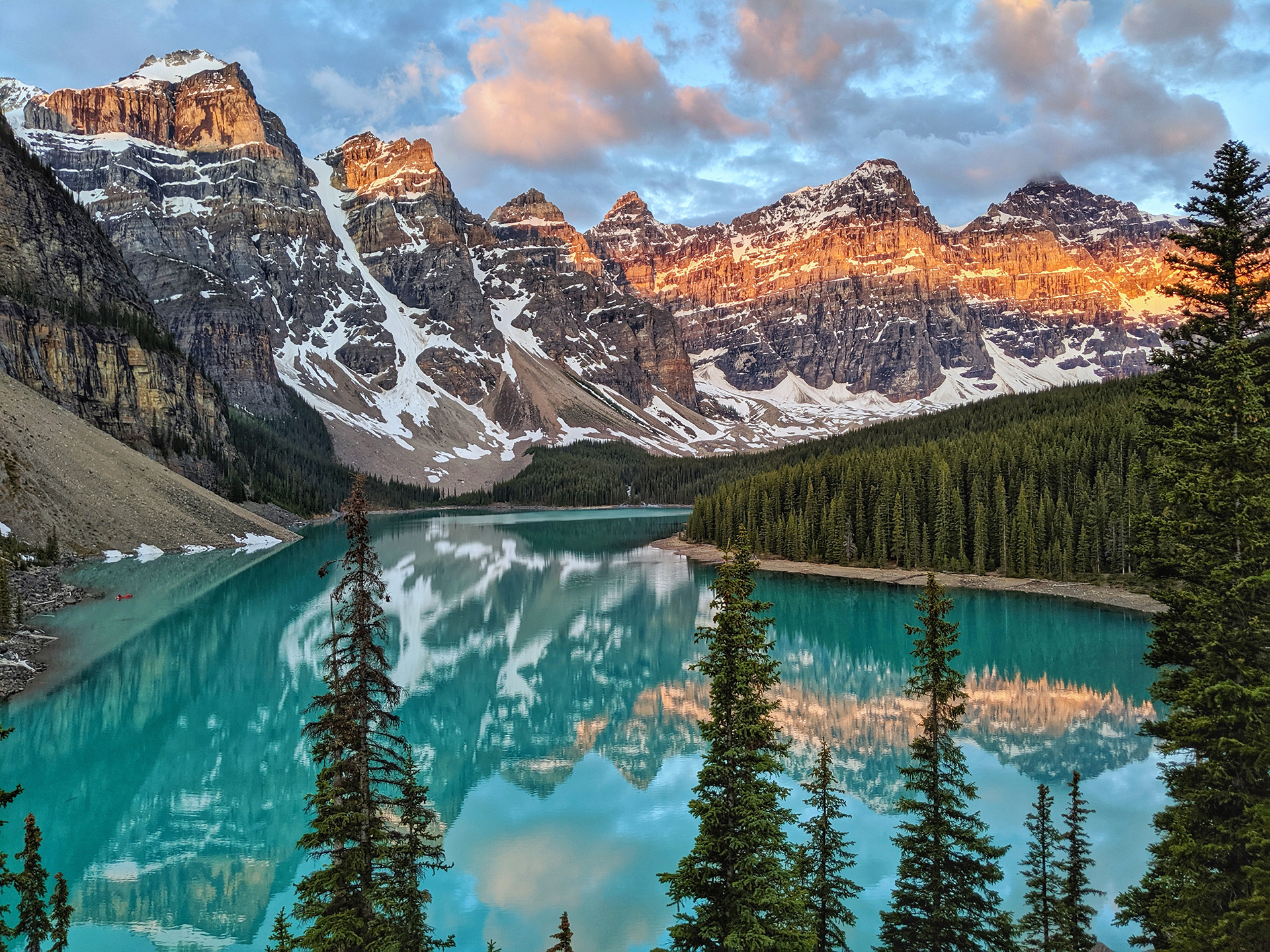 A lake and mountain view by a pine forest in the Canadian Rockies