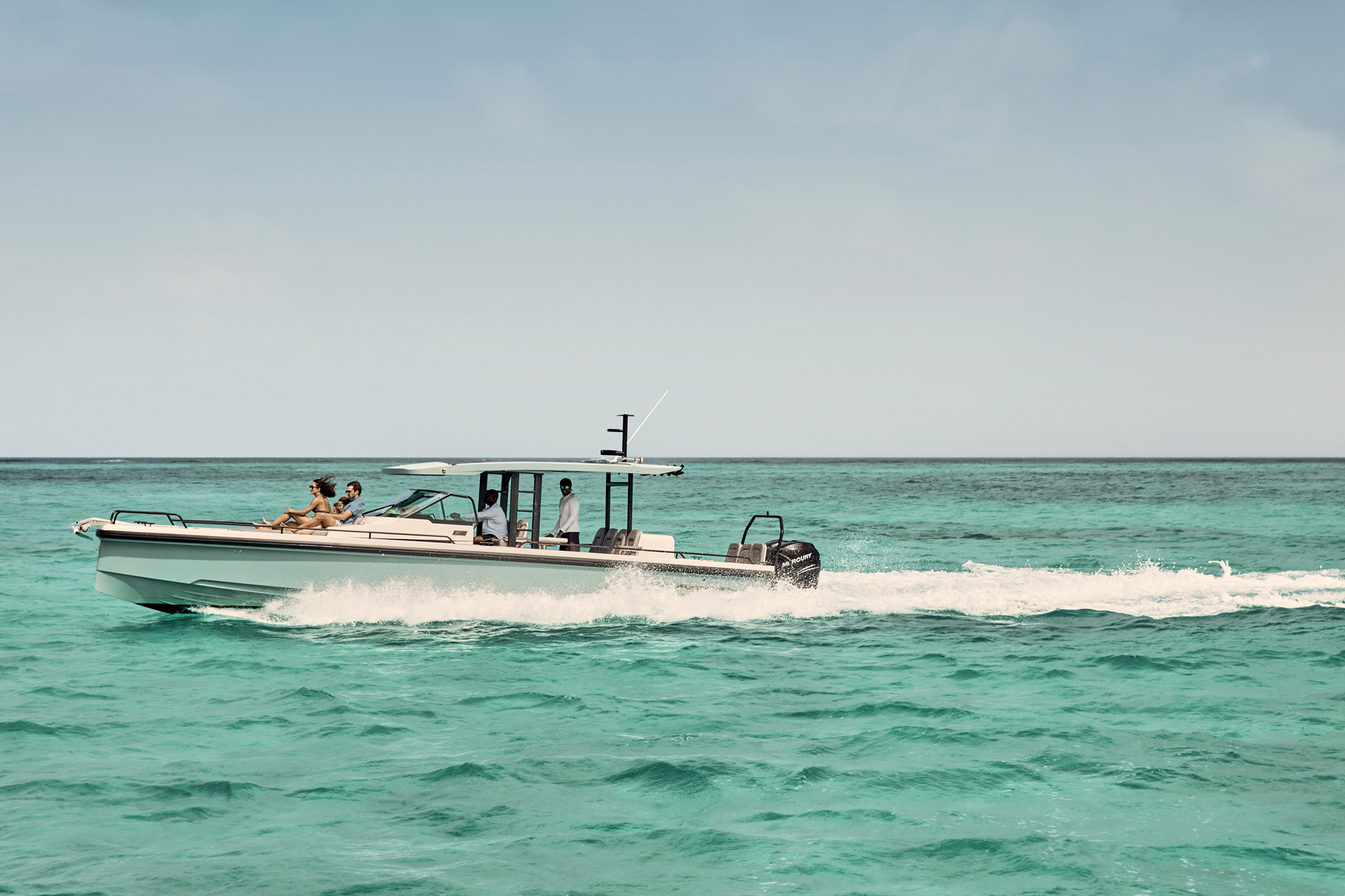 A family sat on the front of a white motored boat