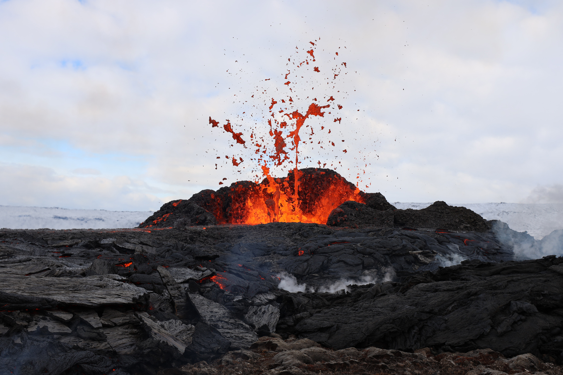Lava exploding from a dark rocky surface
