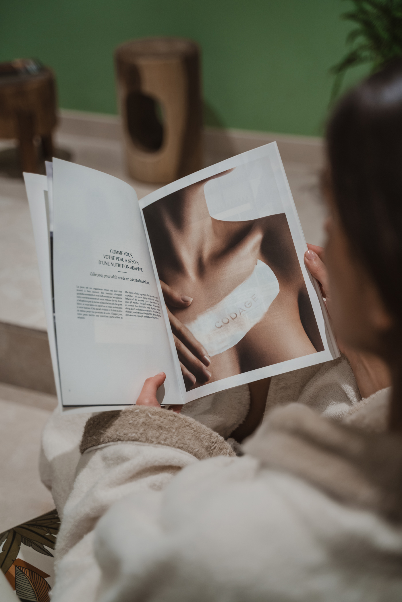 A woman in a soft dressing gown reading a magazine in the spa at Hotel Kimpton Aysla