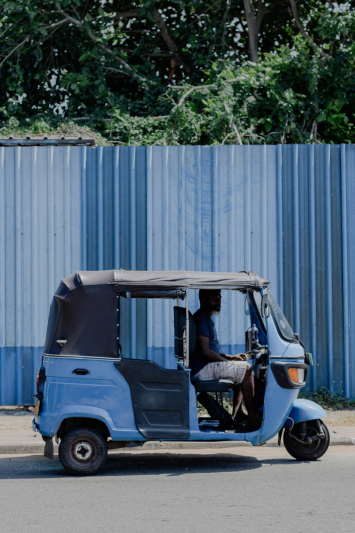 Man driving blue tuk tuk in Sri Lanka