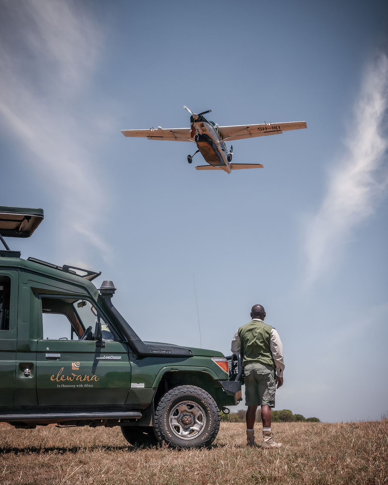 Safari guide looking up at SkySafari plane as it flies overhead