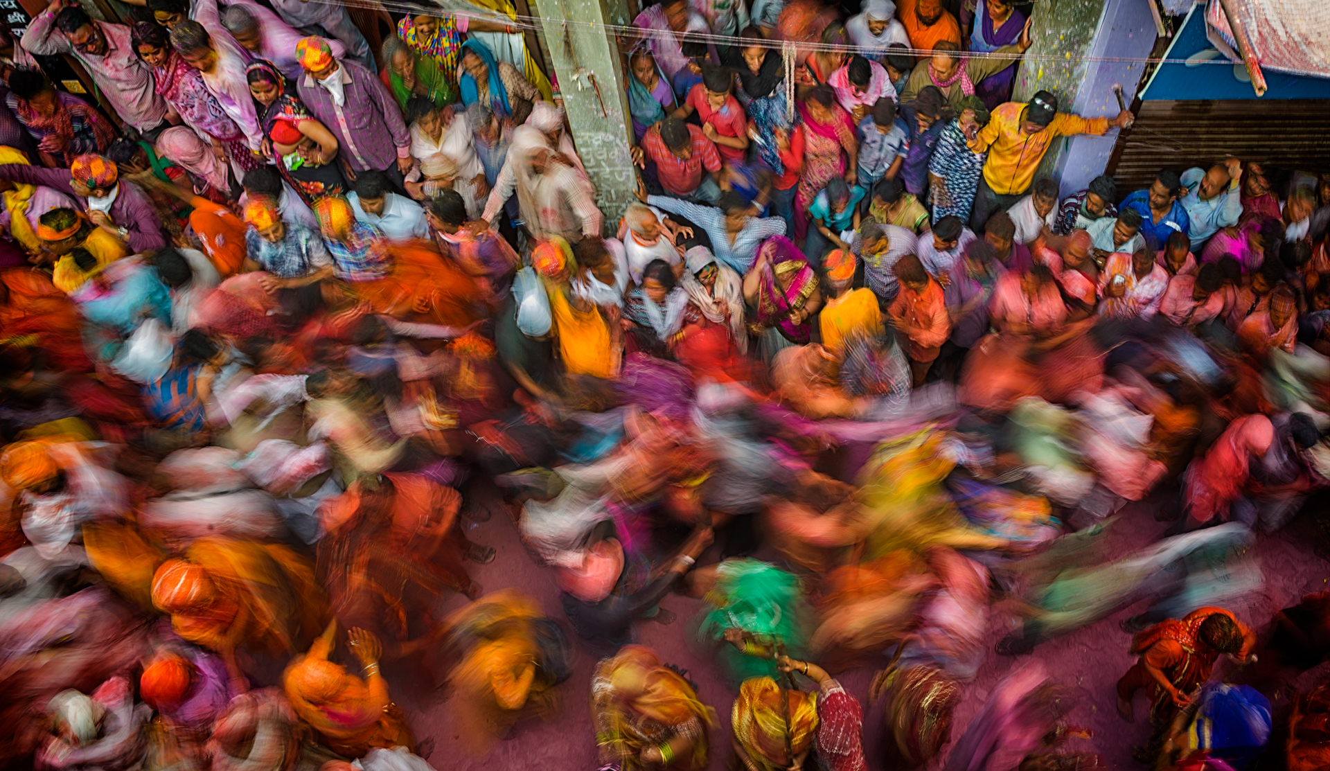 An aerial view of a blurred streak of people as they pass through a busy street