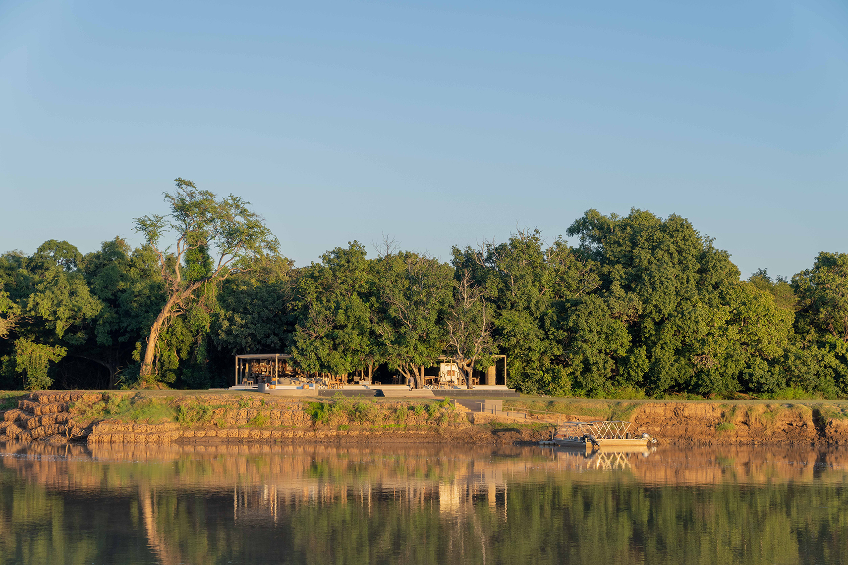 Africa, Zambia, Time + Tide Chinzombo, main area exterior view from the river