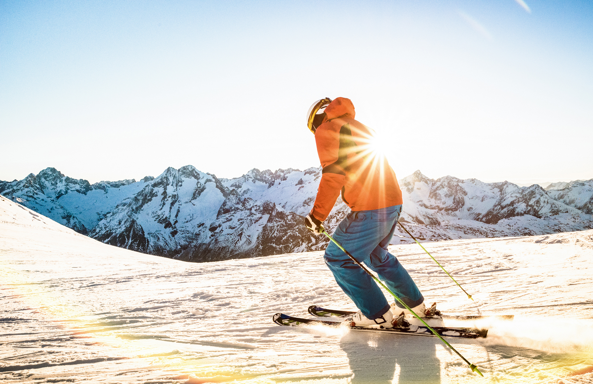 Skier skiing at sunset on top of a mountain