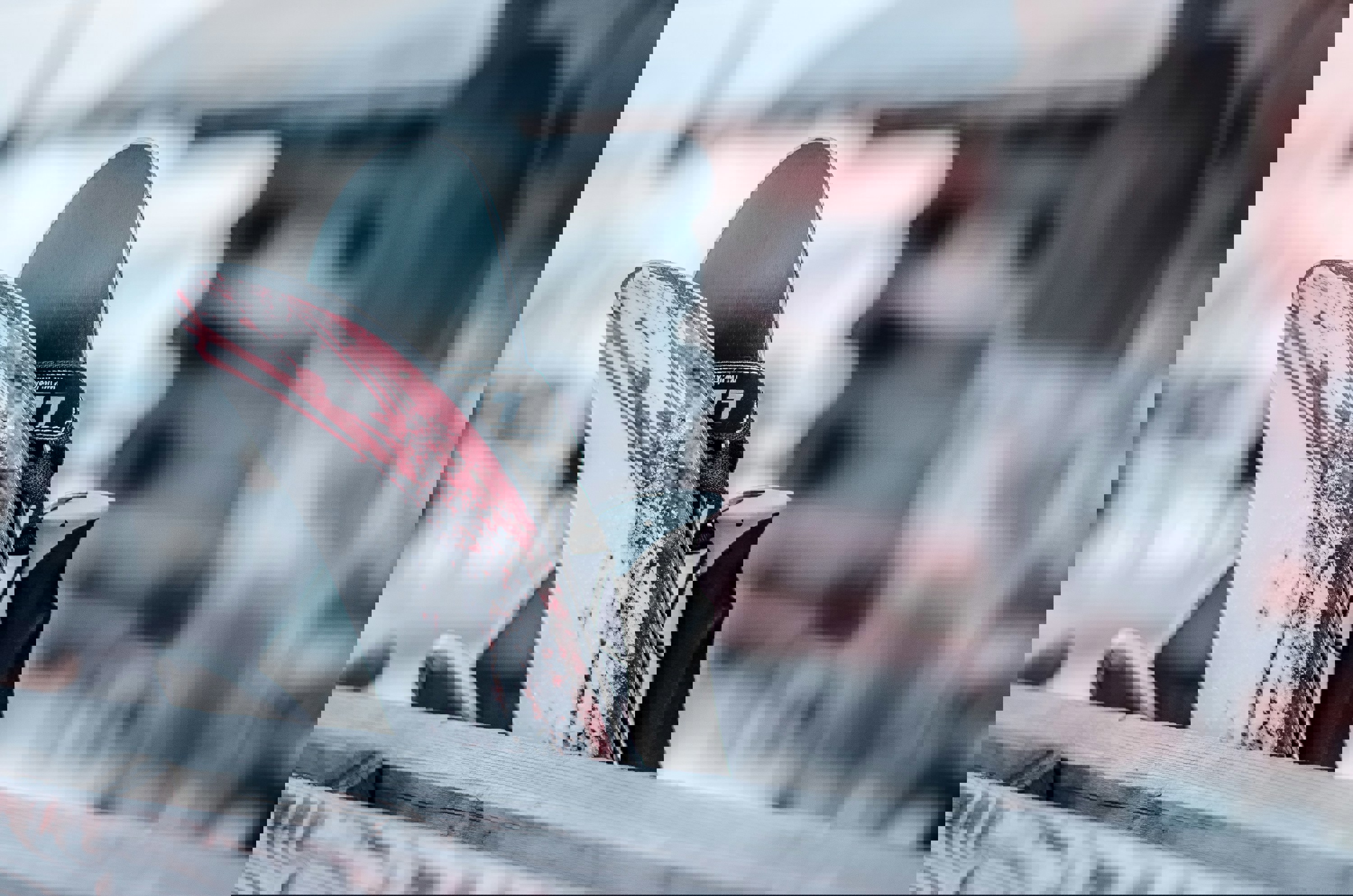 A close-up of skis and bindings, with a focus on the textures and snow residue, suggesting recent use or preparation for skiing