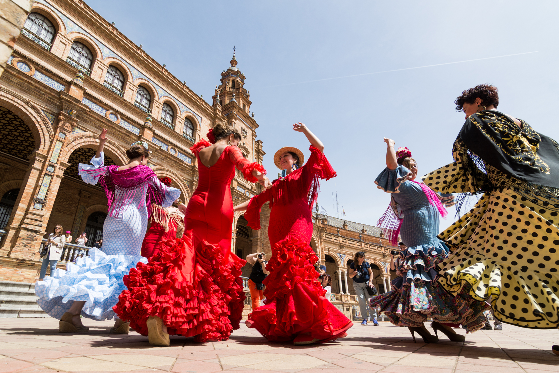 Woman wearing flemenco dresses and dancing on Plaza de Espana