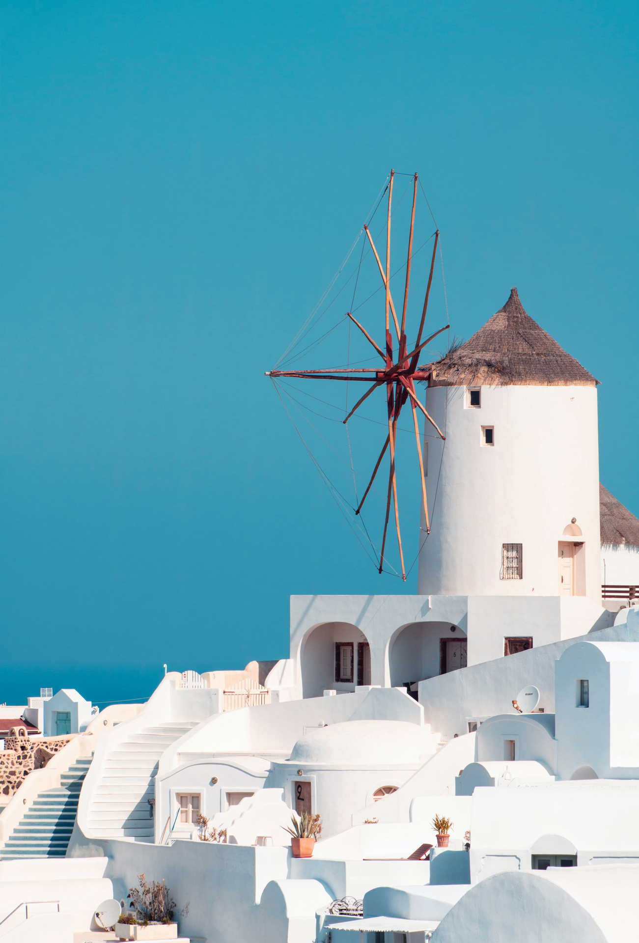 White buildings and a white windmill with a brown straw roof