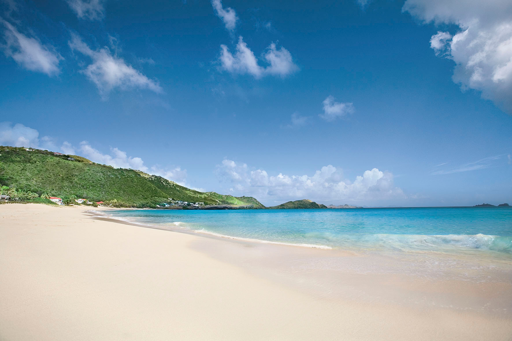 A flat beach with hills in the background