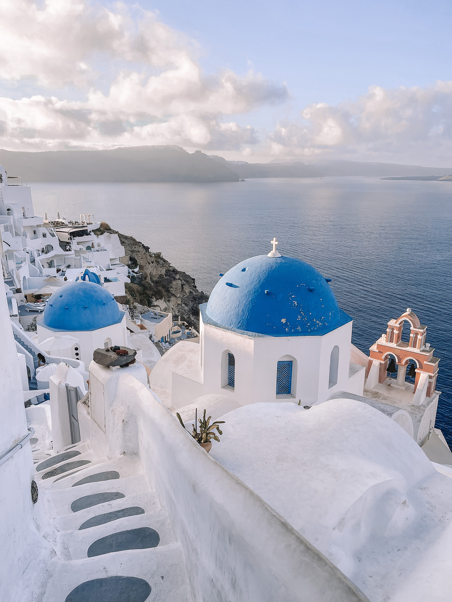 A coastal town in Greece with white concrete buildings with blue roofs