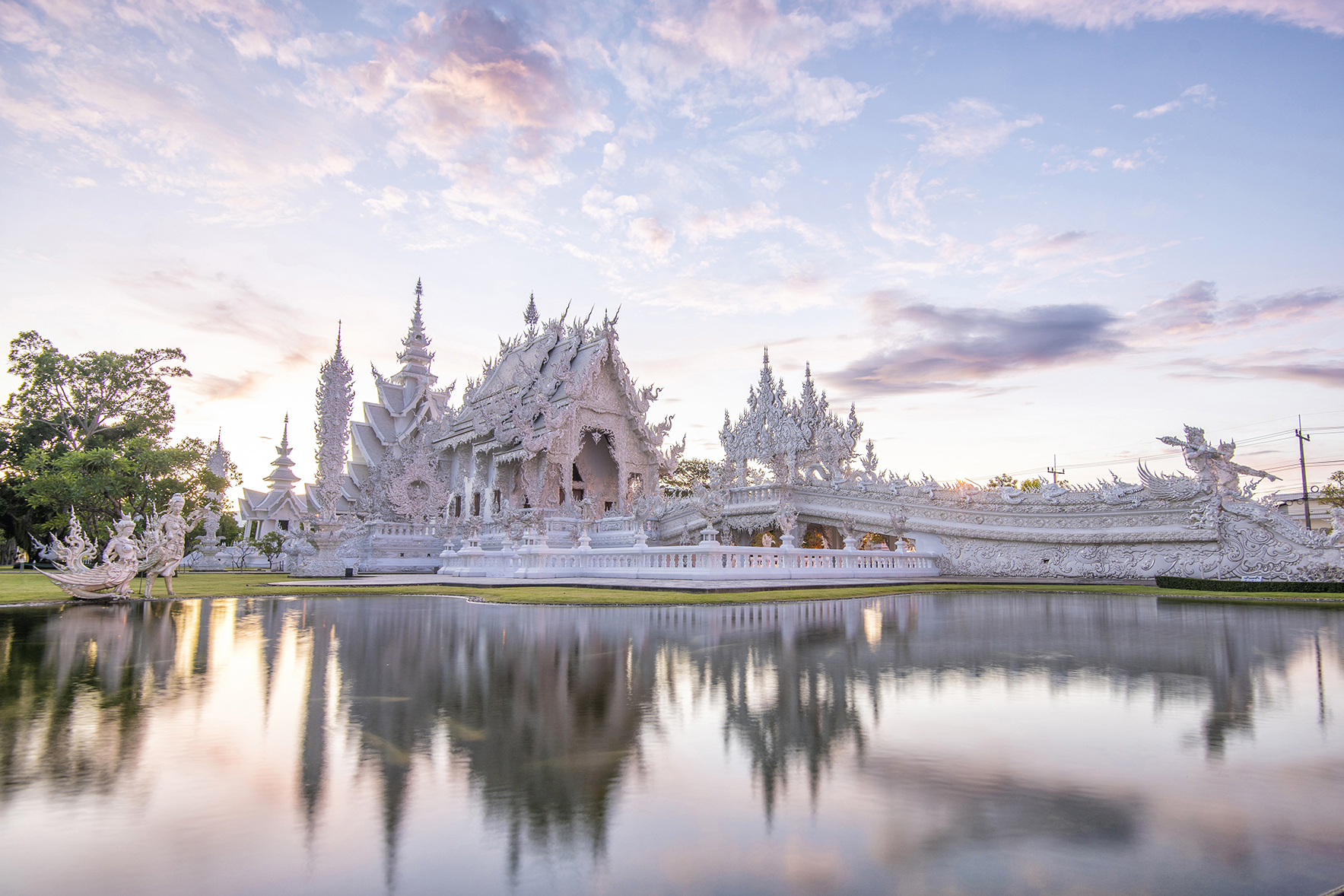 Wat Rong Khun (white temple) in Thailand reflected in lake